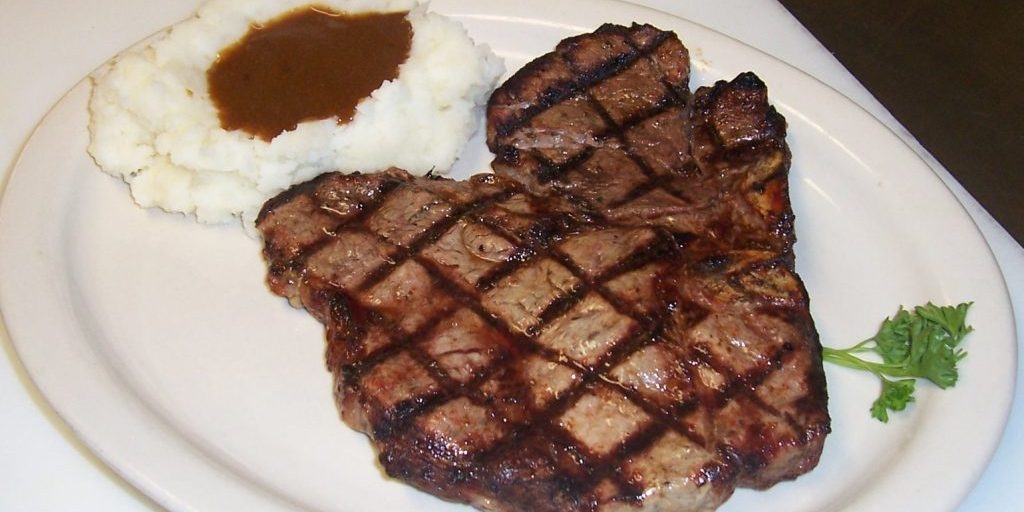 T-bone steak with sear marks and mashed potatoes with brown gravy. Yum!